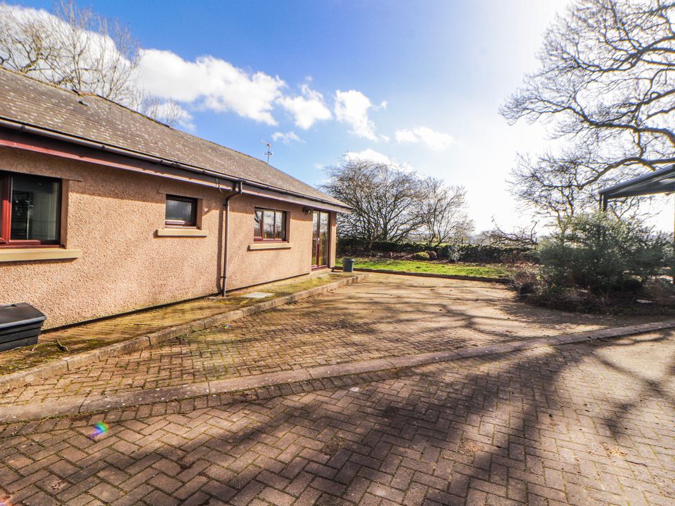 A house with a paved area and trees at Old Riggs Paddock Penrith