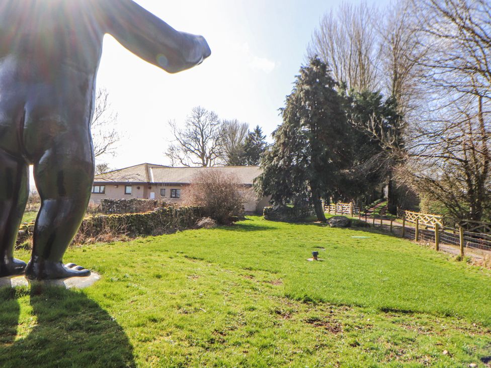 A garden with a statue and a house at Old Riggs Paddock in Penrith