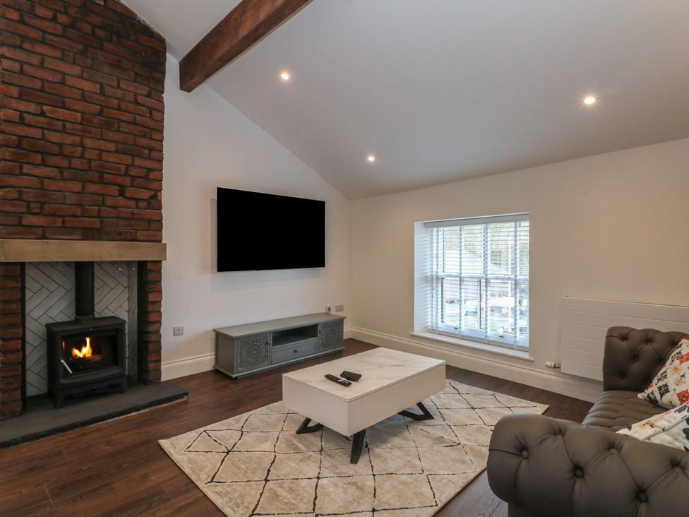 A living room with a fireplace and television at The Penthouse at 86 Rossendale