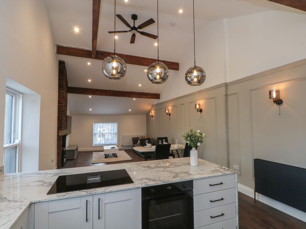 A kitchen with marble countertop and dining area at The Penthouse at 86 Rossendale