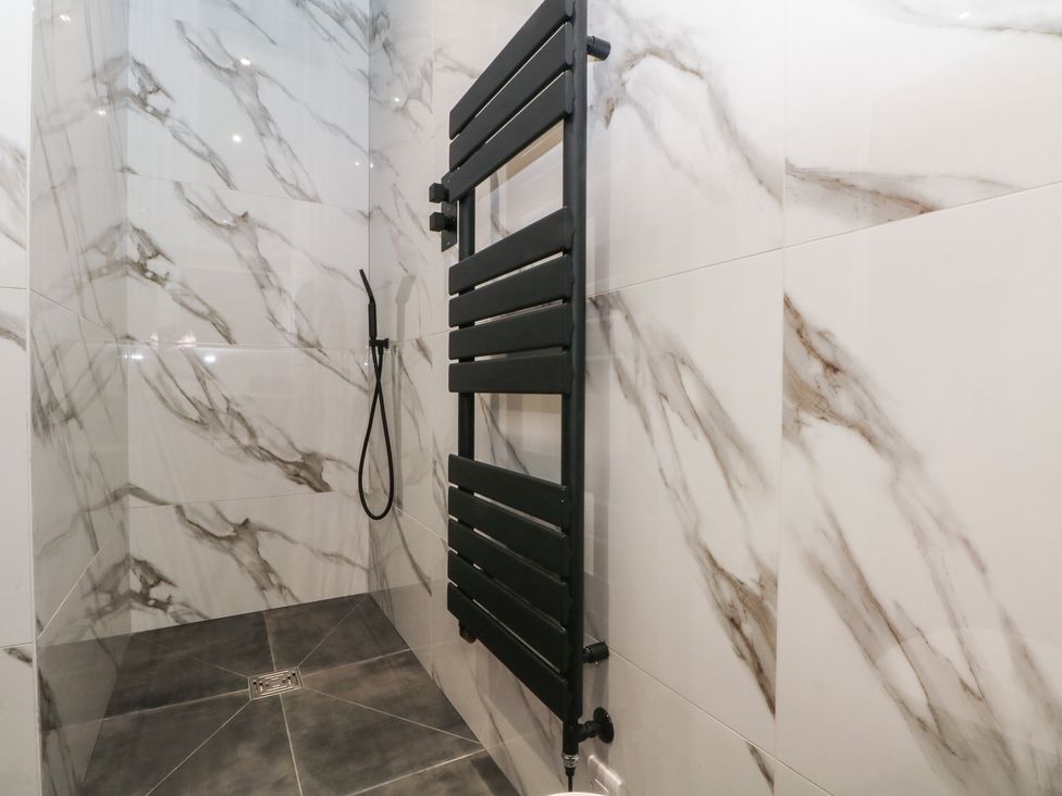 A bathroom with a shower and towel radiator at The Penthouse at 86 Rossendale