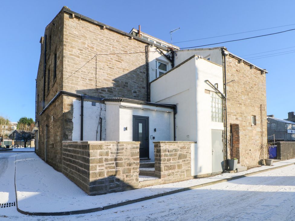 An exterior view of a building with an entrance and snow at The Penthouse at 86 Rossendale