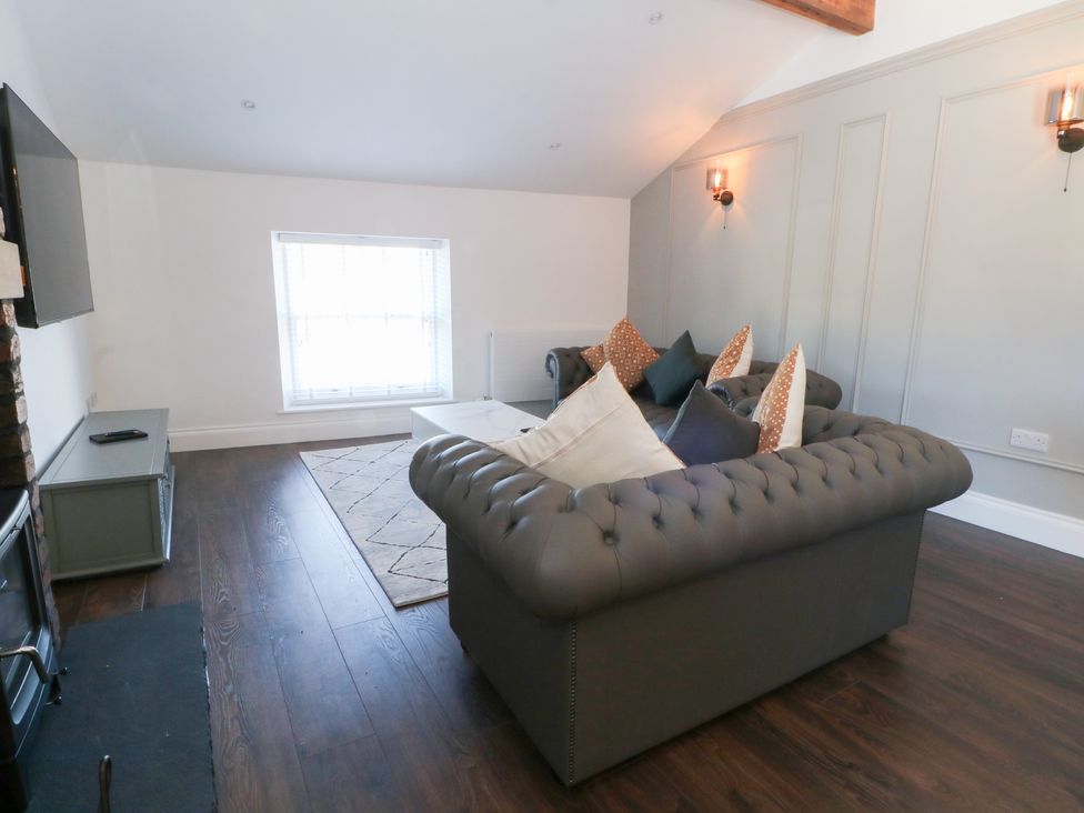 A living room with a sofa and television at The Penthouse at 86 in Rossendale