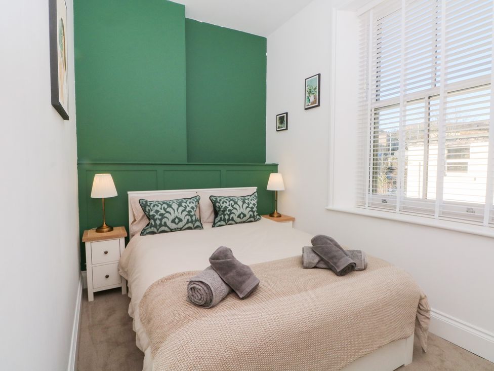 A bedroom with a bed and nightstands at The Penthouse at 86 Rossendale