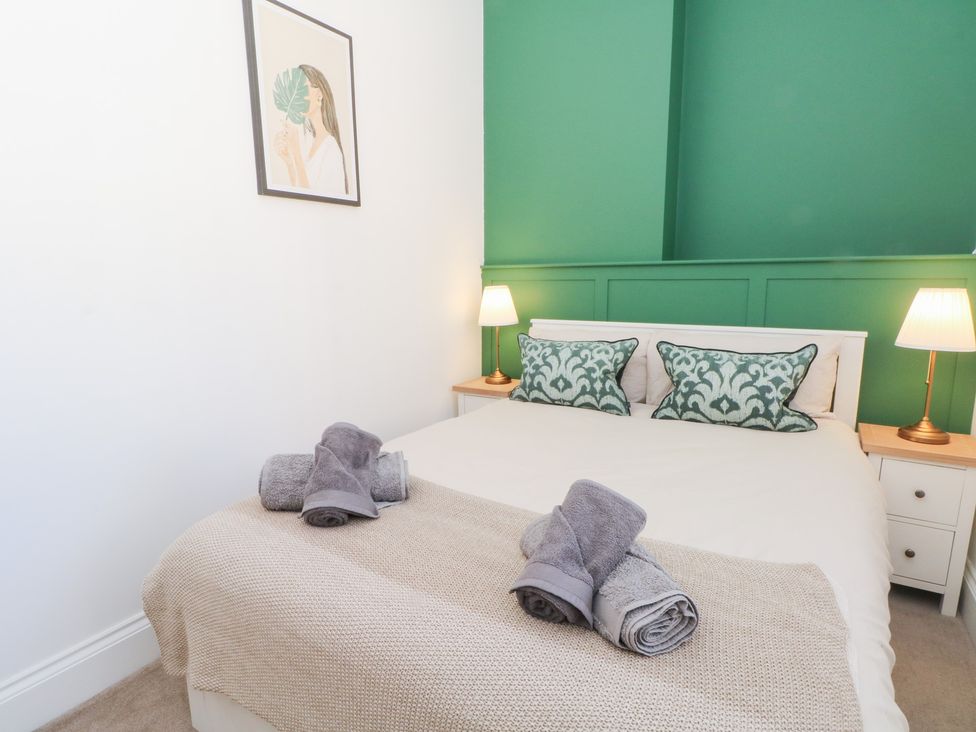 A bedroom with a bed and bedside tables at The Penthouse at 86, Rossendale