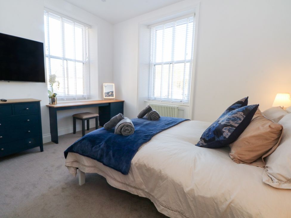 A bedroom with a bed and desk at The Penthouse at 86 Rossendale