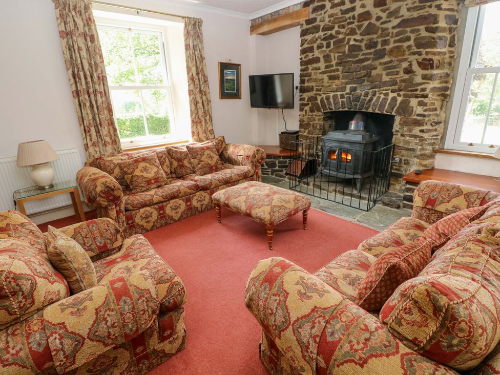 A living room with a fireplace and seating area at The Sycamores in Llawhaden near Narberth