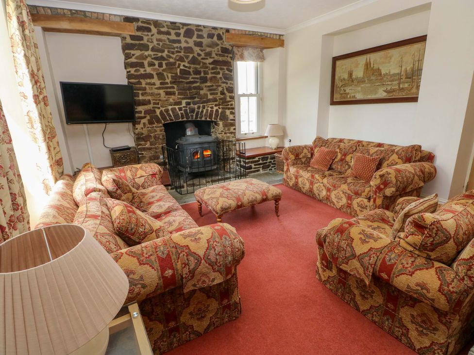 A living room with a fireplace and sofas at The Sycamores in Llawhaden near Narberth