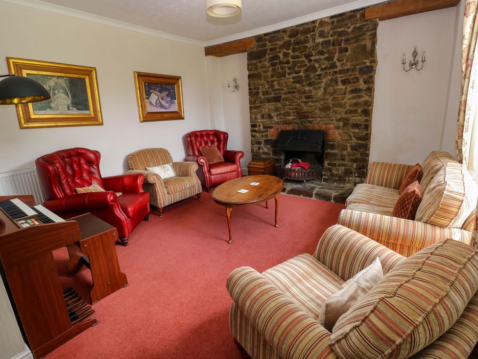 A living room with a fireplace and seating at The Sycamores in Llawhaden near Narberth