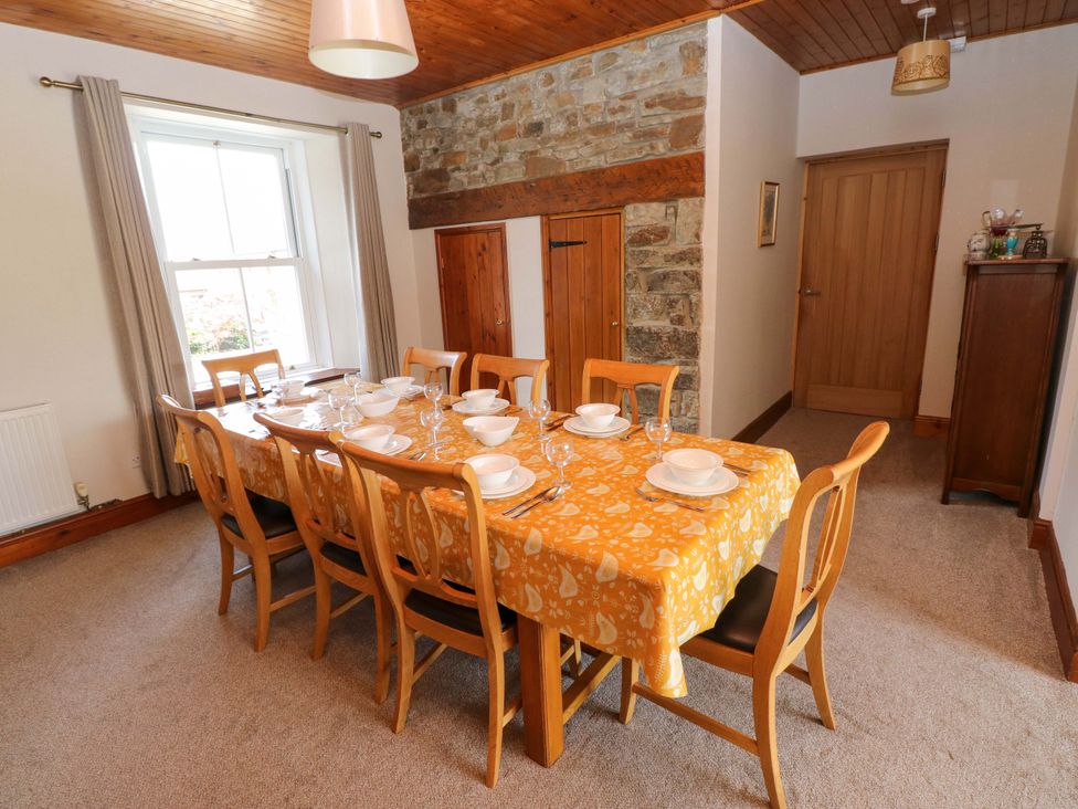 A dining room with a table set for dinner at The Sycamores in Llawhaden near Narberth