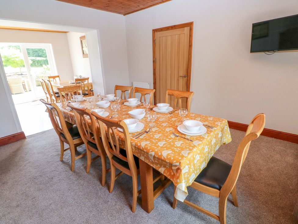 A dining room with a table set for dinner at The Sycamores in Llawhaden near Narberth