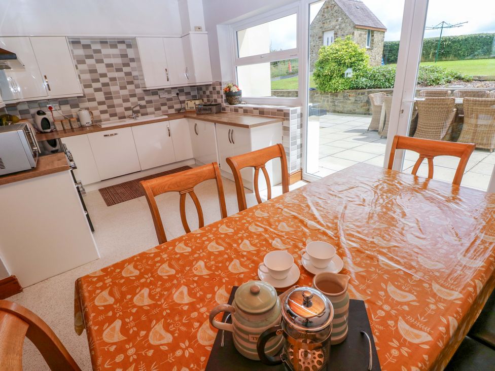 A kitchen with a dining table and tea set at The Sycamores in Llawhaden near Narberth