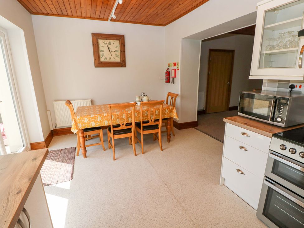 A kitchen with a dining table and chairs at The Sycamores in Llawhaden near Narberth