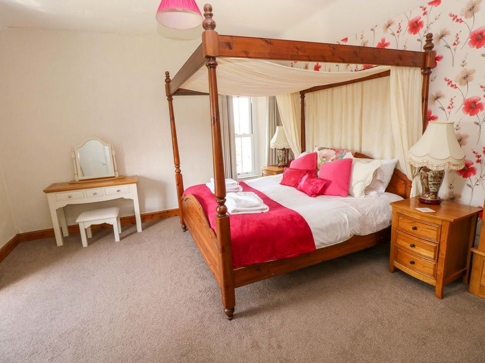 A bedroom with a four-poster bed and vanity table at The Sycamores Llawhaden near Narberth