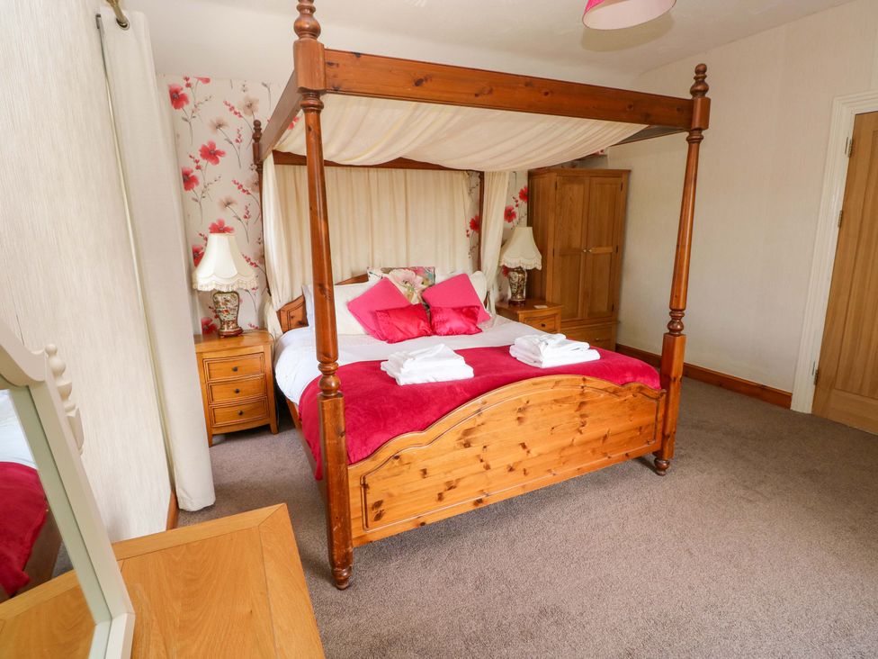 A bedroom with a four-poster bed and bedside tables at The Sycamores in Llawhaden near Narberth