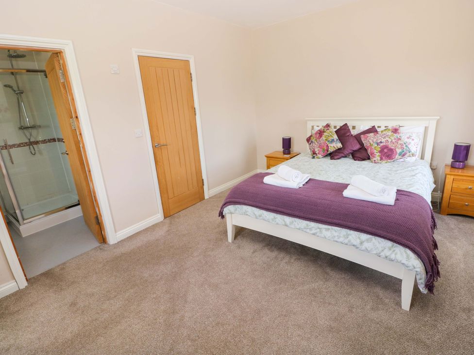 A bedroom with a bed and shower access at The Sycamores in Llawhaden near Narberth