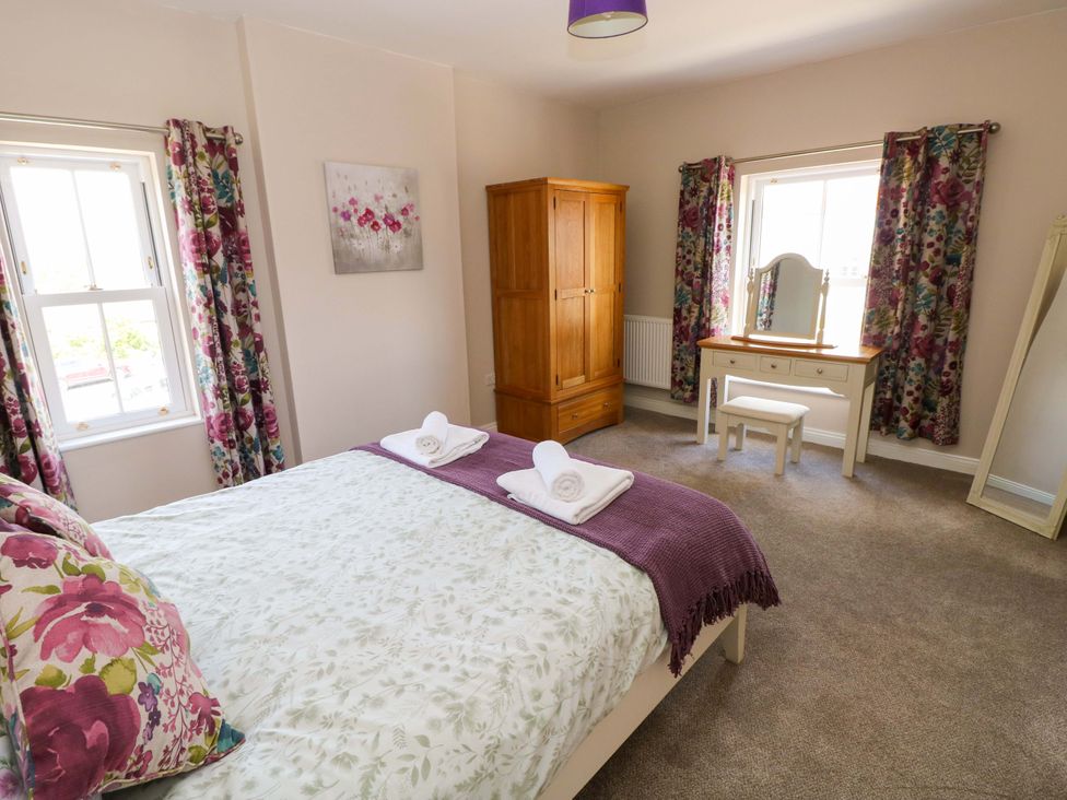 A bedroom with a bed and wardrobe at The Sycamores in Llawhaden near Narberth