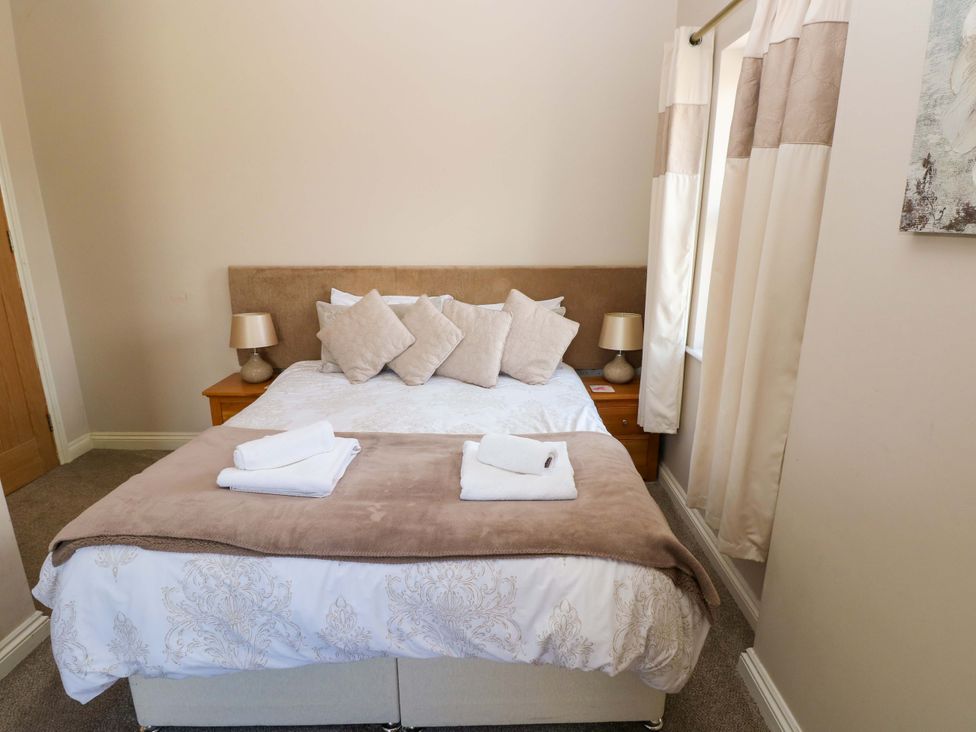 A bedroom with a double bed and bedside table at The Sycamores, Llawhaden near Narberth