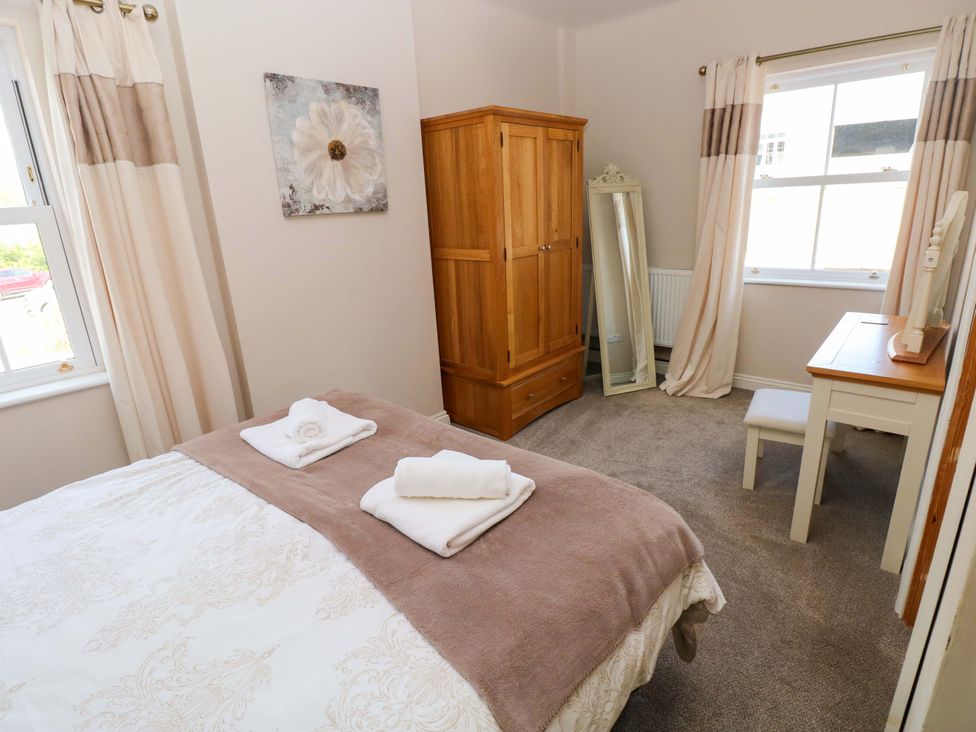 A bedroom with a bed and wardrobe at The Sycamores Llawhaden near Narberth