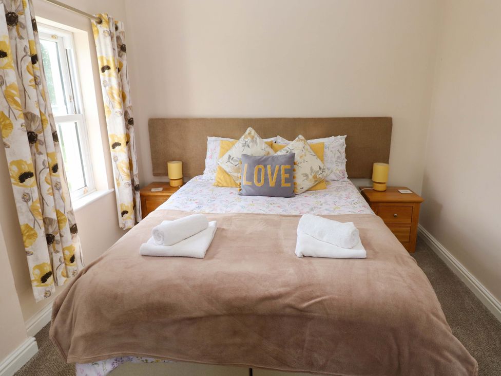 A bedroom with a bed and bedside table at The Sycamores in Llawhaden near Narberth
