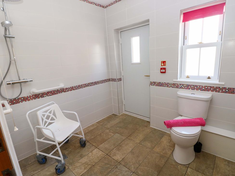 A bathroom with a shower and wheelchair at The Sycamores in Llawhaden near Narberth