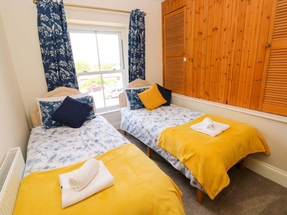 A bedroom with two single beds and a window at The Sycamores in Llawhaden near Narberth