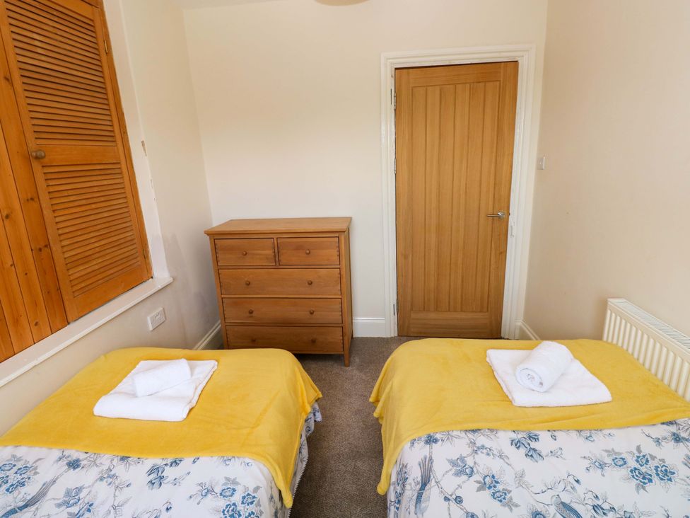 A bedroom with two beds and a dresser at The Sycamores in Llawhaden near Narberth