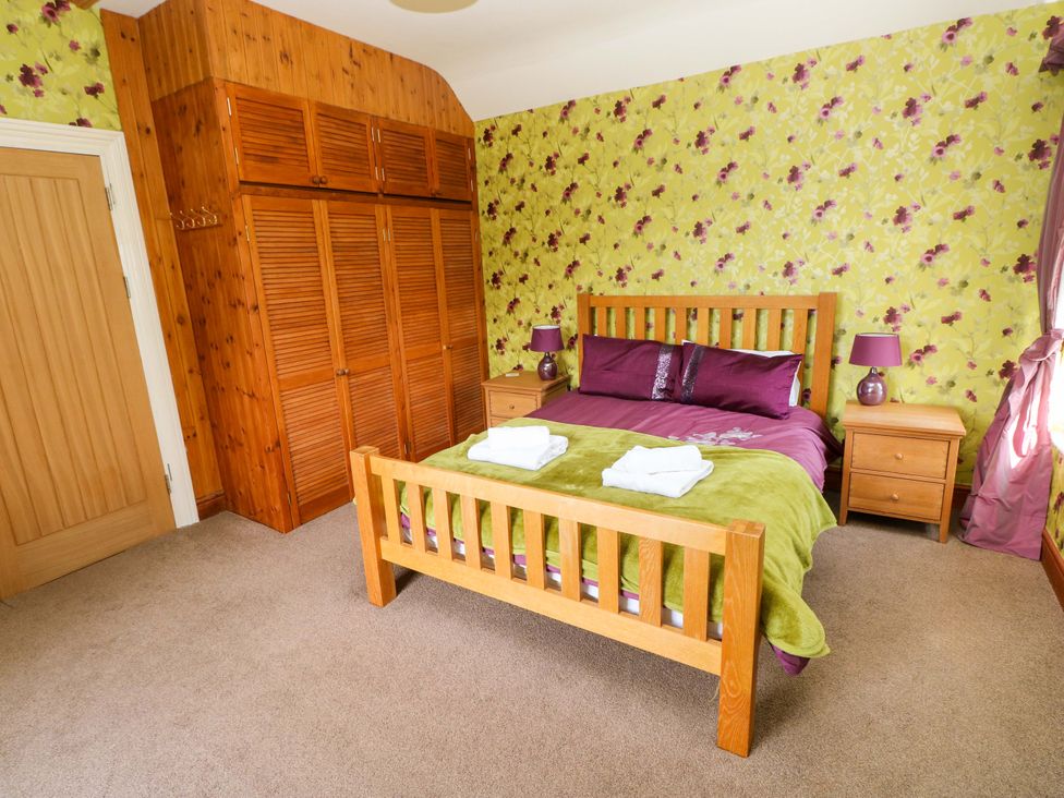 A bedroom with a bed and wardrobe at The Sycamores Llawhaden near Narberth
