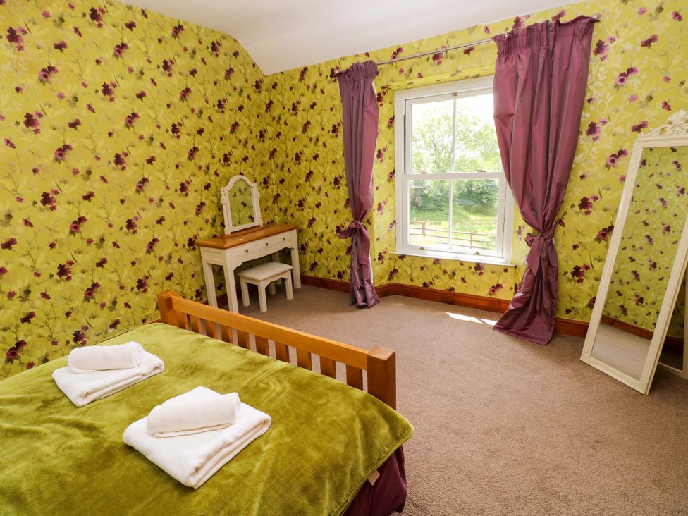 A bedroom with a bed and dressing table at The Sycamores in Llawhaden near Narberth