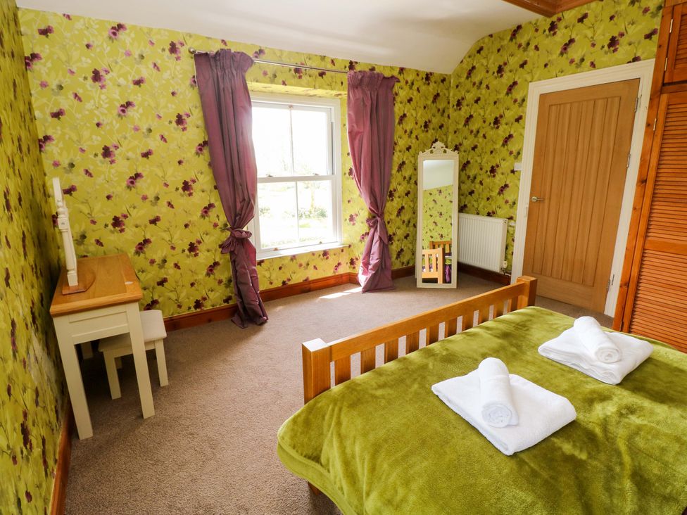 A bedroom with a bed and desk at The Sycamores in Llawhaden near Narberth