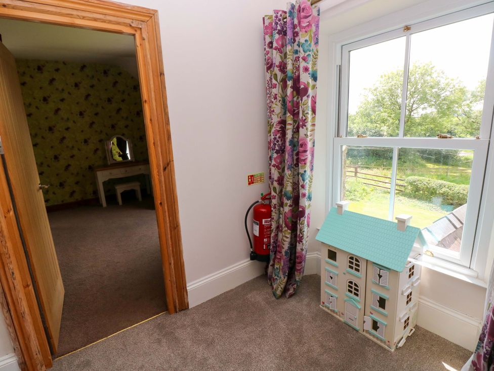 A bedroom with a dollhouse and a fire extinguisher at The Sycamores in Llawhaden near Narberth