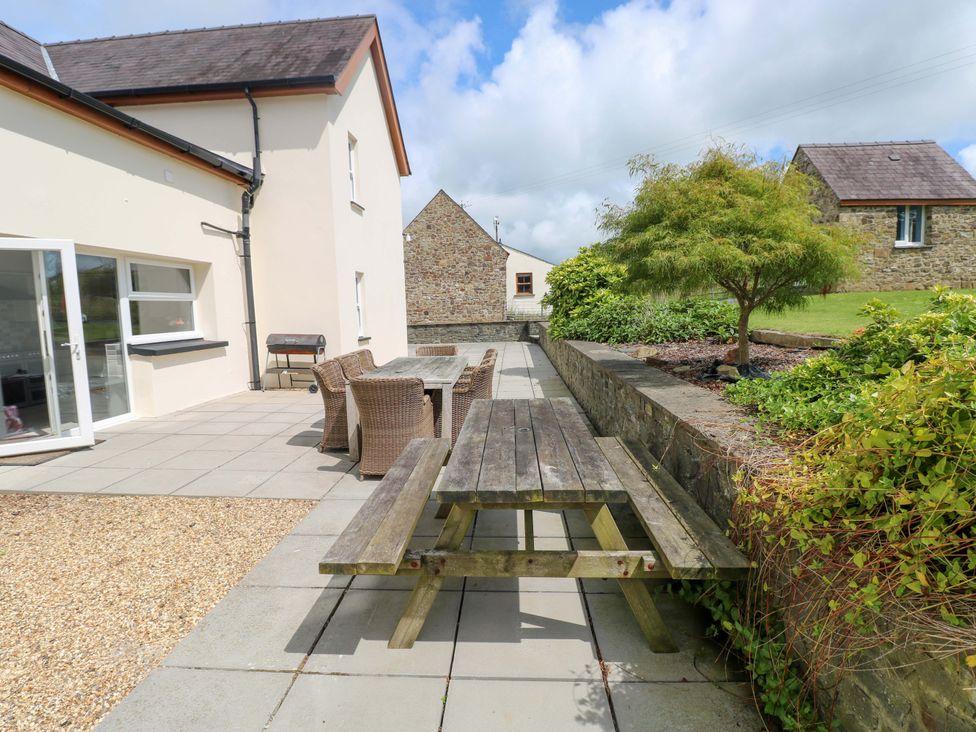 An outdoor seating area with a table and chairs at The Sycamores in Llawhaden near Narberth