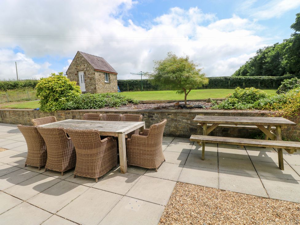 An outdoor area with a table and chairs at The Sycamores in Llawhaden near Narberth