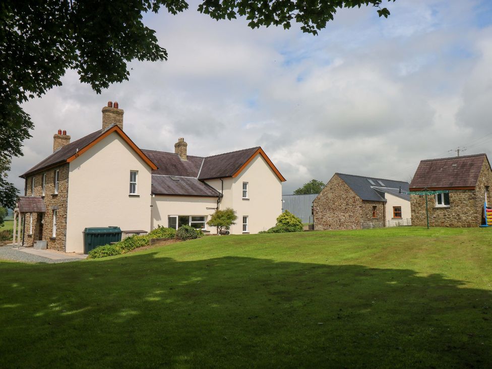 A house and garage with green grass and trees at The Sycamores in Llawhaden near Narberth