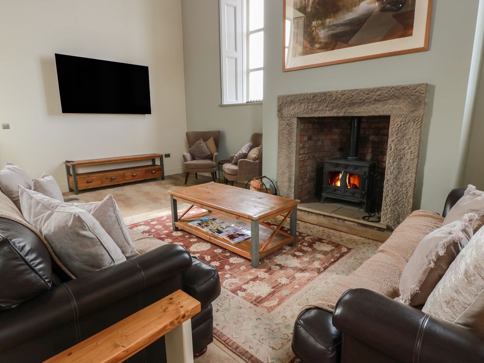 A living room with a tv, fireplace, and seating at The Old Chapel in Norham
