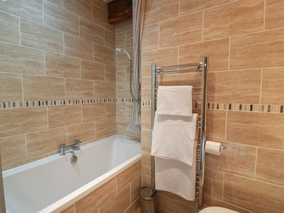 A bathroom with a bathtub and towel rail at The Old Chapel in Norham