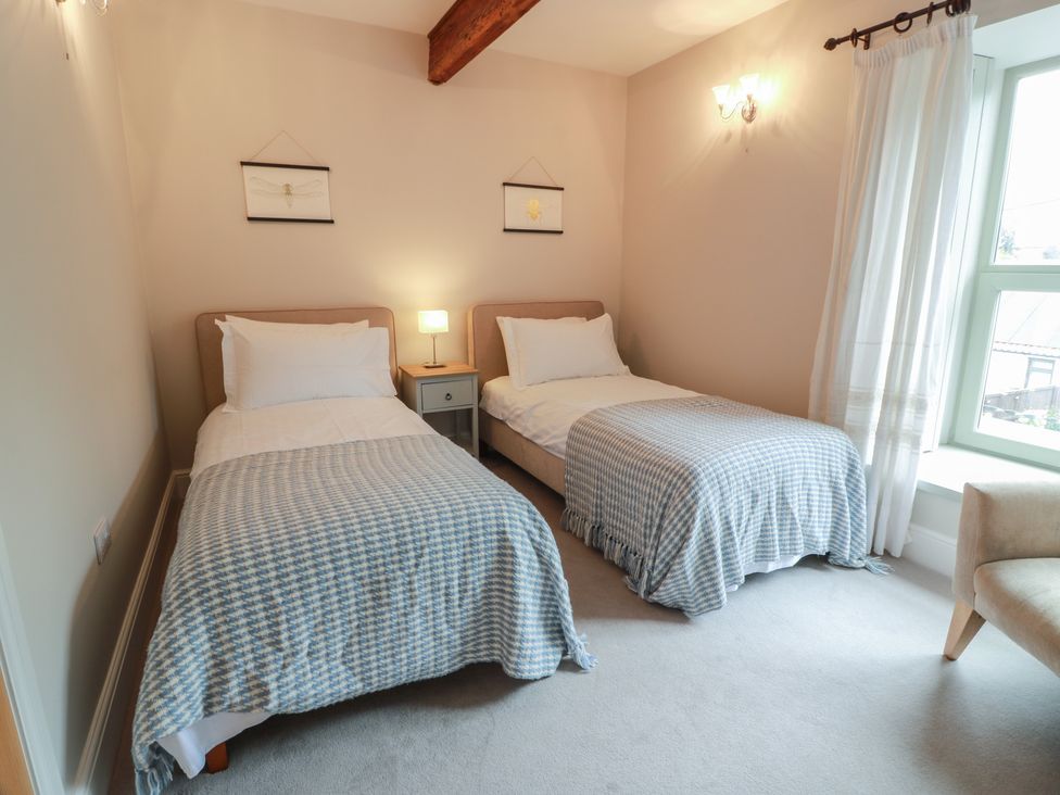 A bedroom with two beds and a window at The Old Chapel in Norham