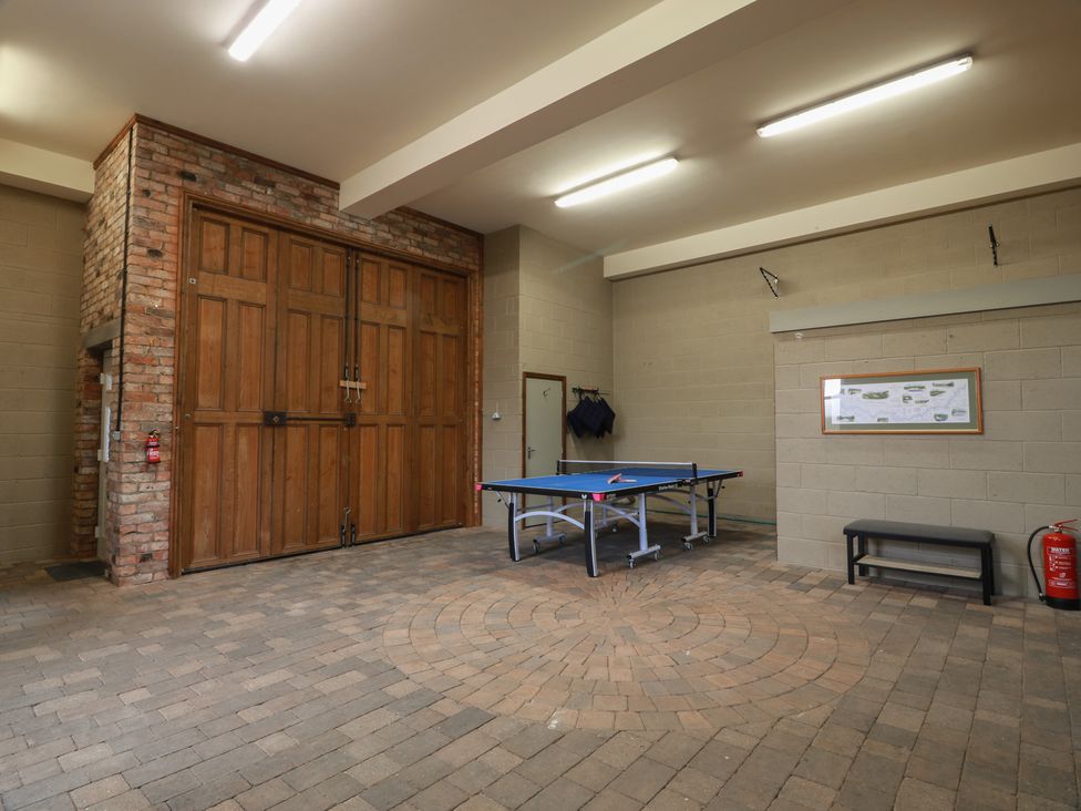 A game room with a ping pong table and garage doors at The Old Chapel Norham