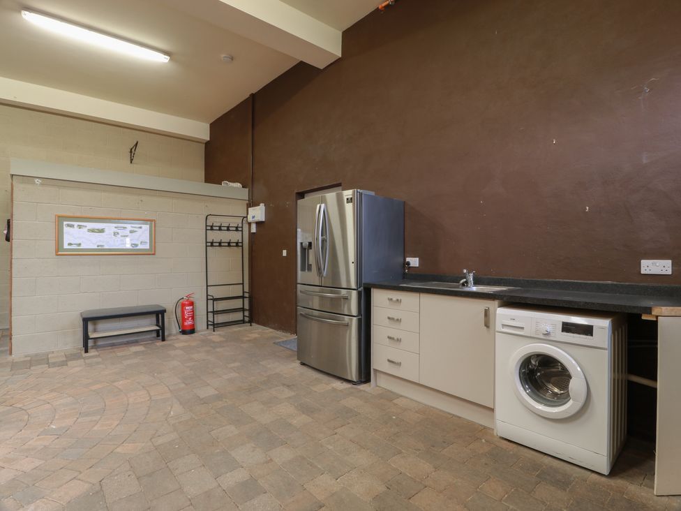 A utility room with a refrigerator and washing machine at The Old Chapel in Norham