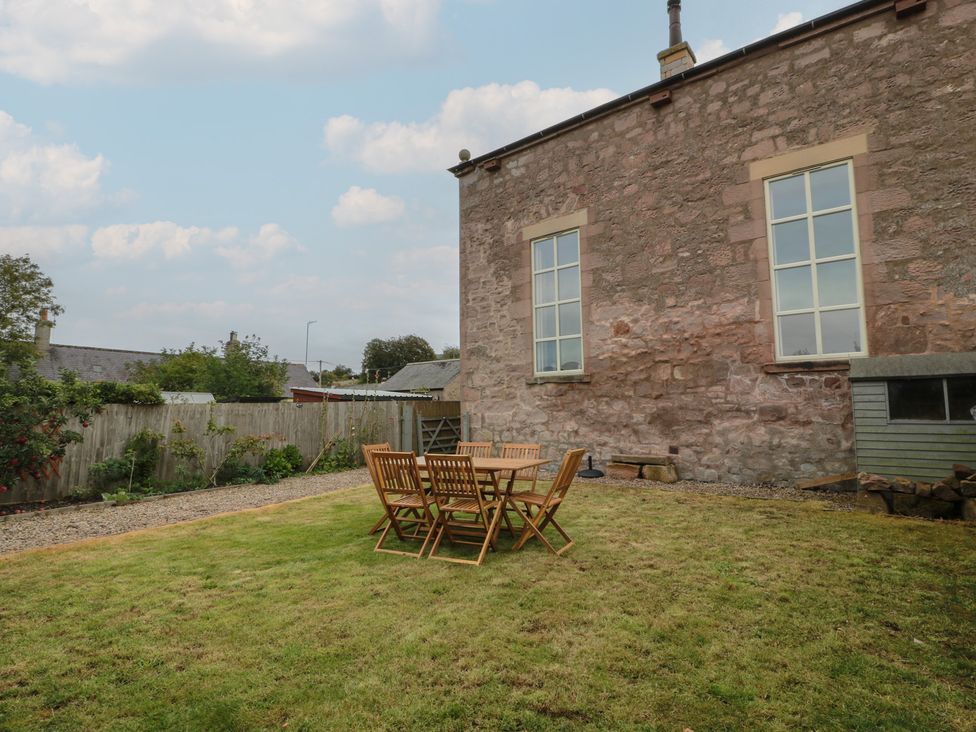 A garden with a wooden table and chairs at The Old Chapel in Norham