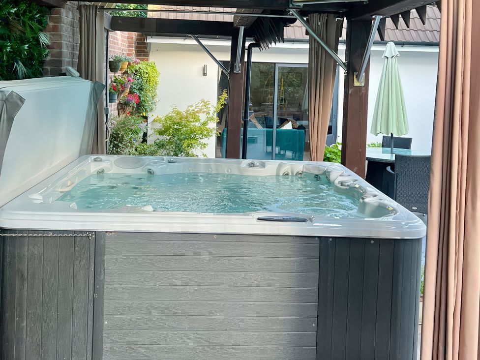 A hot tub with water in an outdoor area at 8 Church Road Ferndown