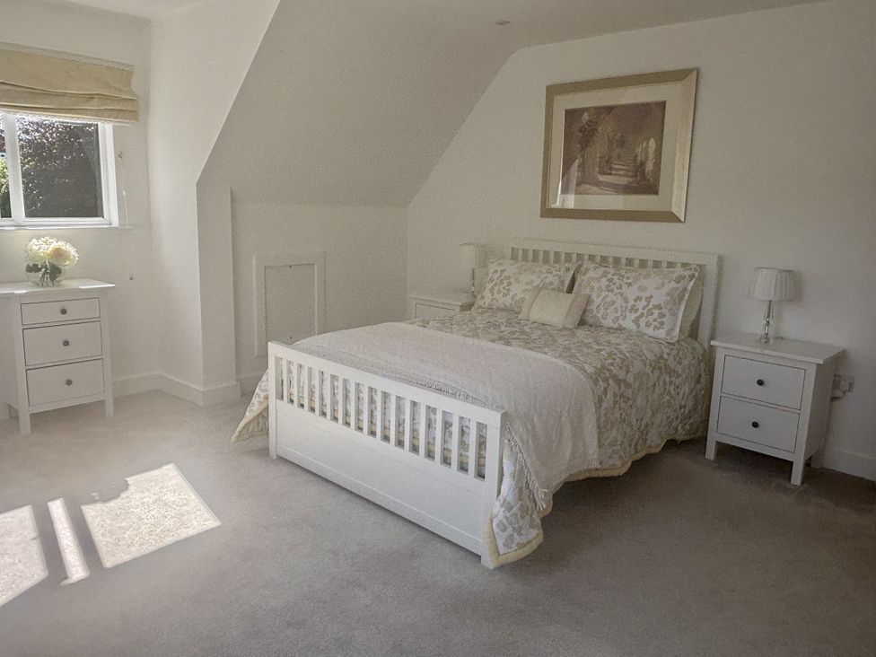A bedroom with a bed and nightstands at 8 Church Road in Ferndown