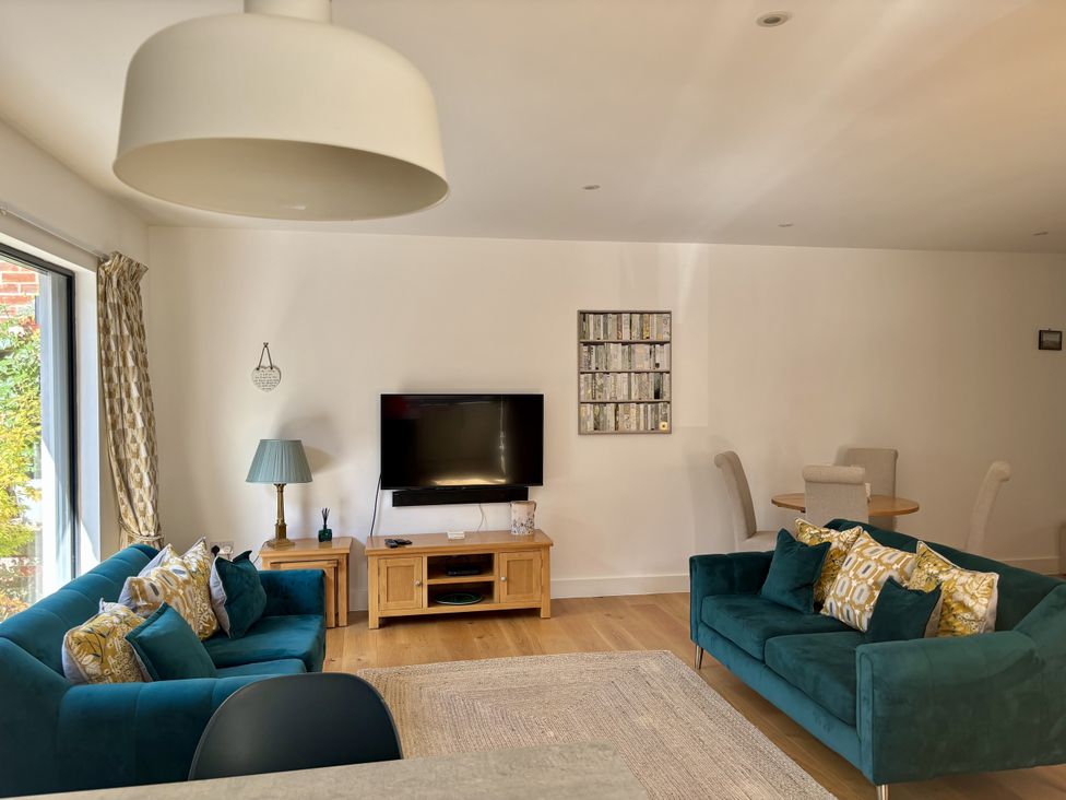A living room with sofas and a television at 8 Church Road Ferndown