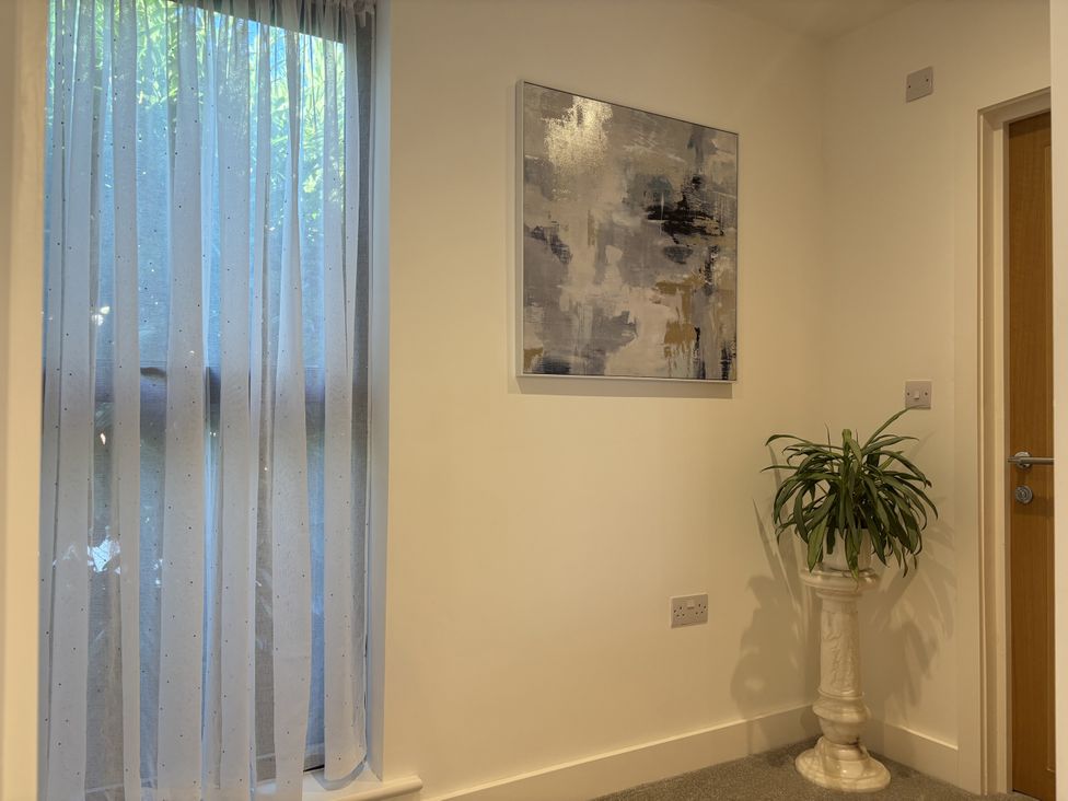 A corner with a curtain, painting, plant and door at 8 Church Road in Ferndown