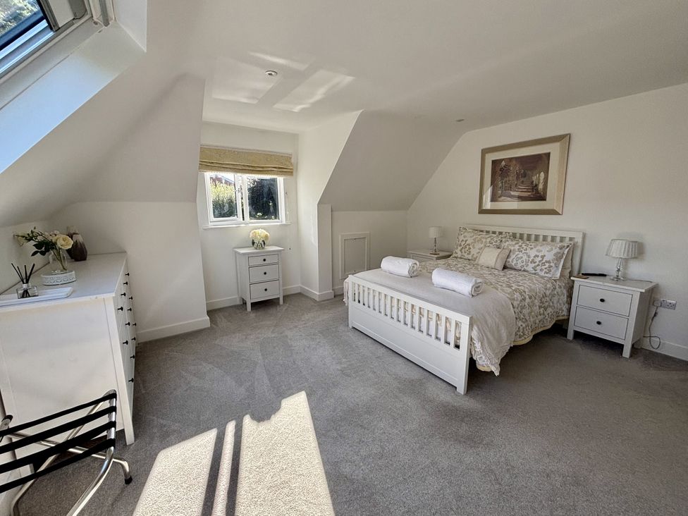 A bedroom with a bed and side tables at 8 Church Road in Ferndown