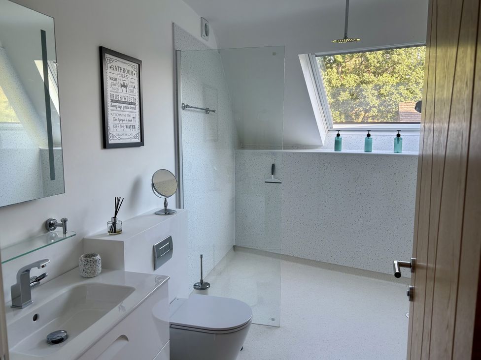 A bathroom with a sink, toilet, and shower at 8 Church Road in Ferndown