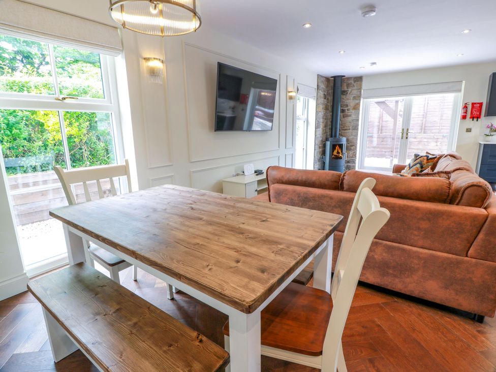 A dining room with a table and sofa at Riverwood House in Gatehouse Of Fleet