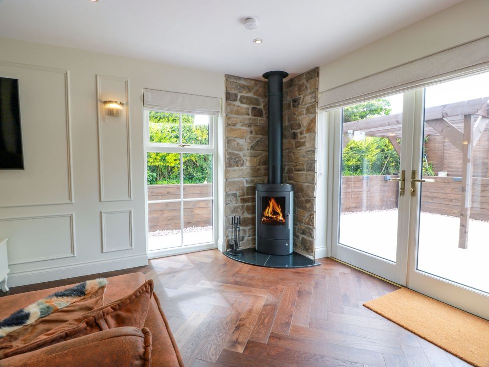 A living room with a fireplace and windows at Riverwood House in Gatehouse Of Fleet