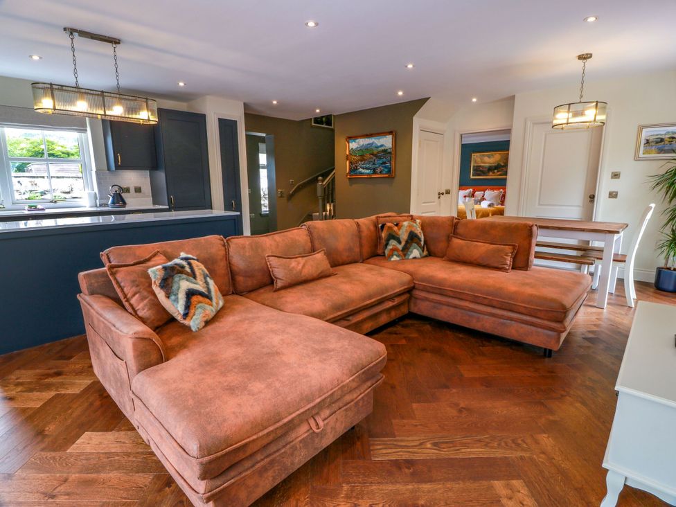 A living room with a sofa and dining table at Riverwood House in Gatehouse Of Fleet