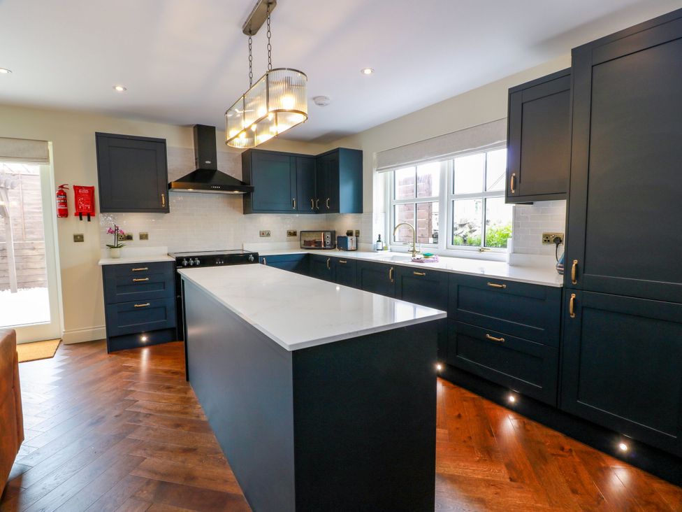 A kitchen with an island and appliances at Riverwood House in Gatehouse Of Fleet